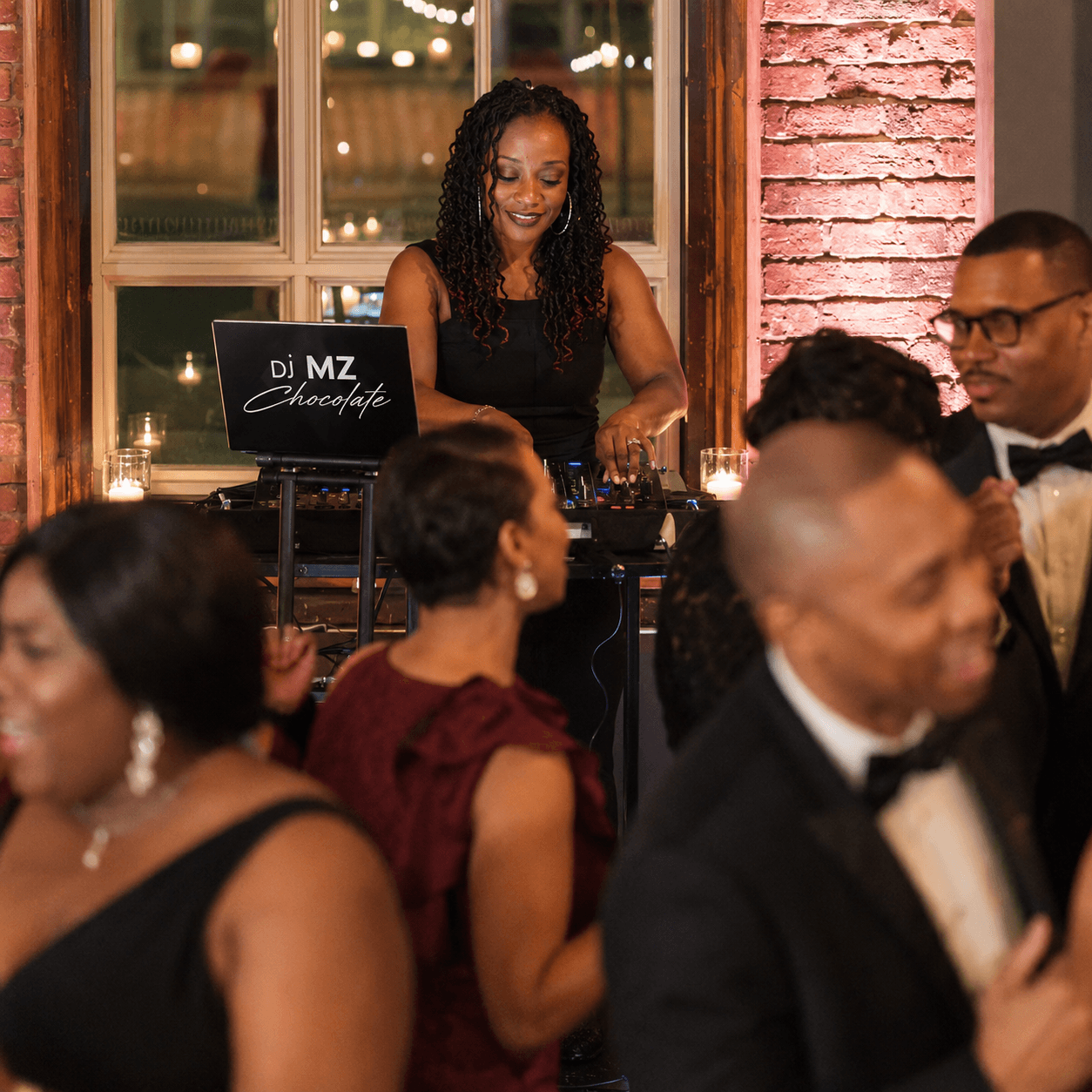 DJ Mz Chocolate behind the DJ booth at a warm event