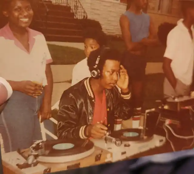 DJ Mz Chocolate’s father behind a DJ setup in Chicago